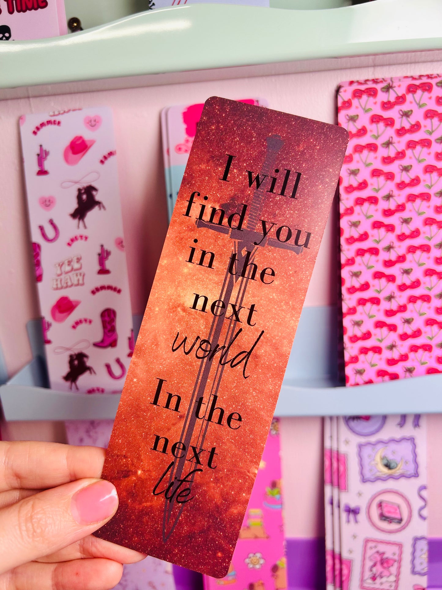 Orange glitter bookmark with face illustration and 'I will find you...' quote, close-up