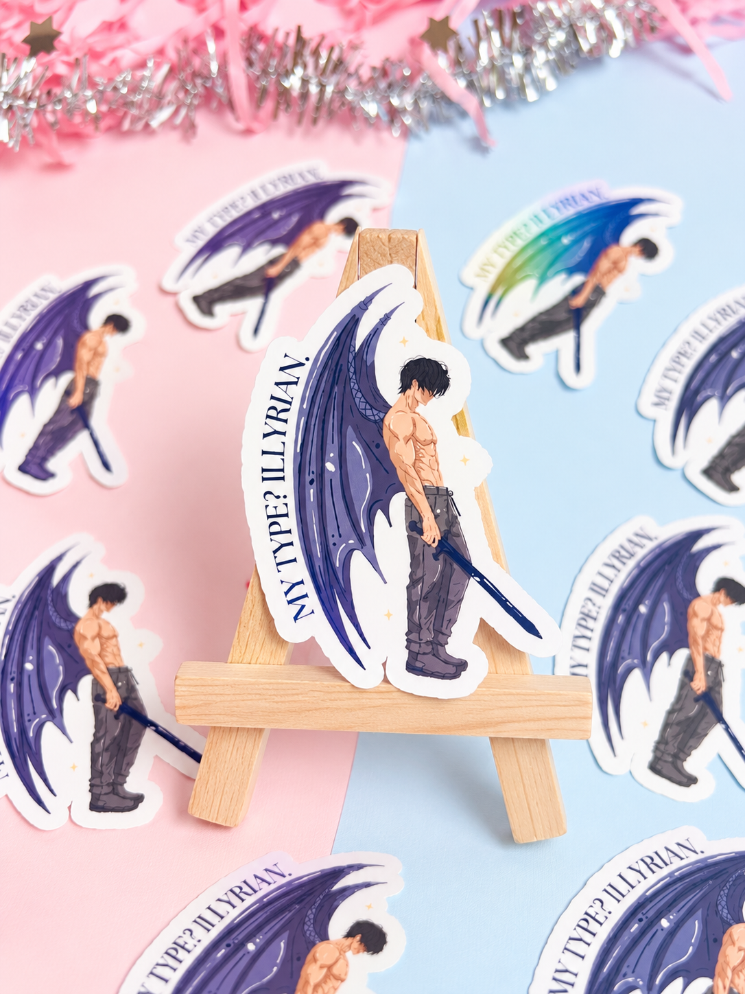 Set of holographic bat-boy character stickers with blue wings and circular text, on mini easel