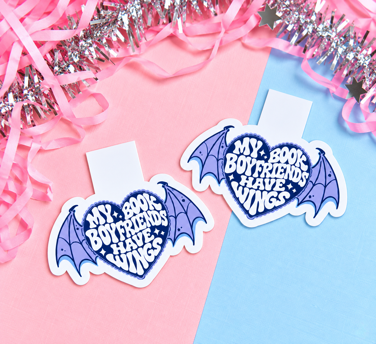 Set of two magnetic bookmarks with blue winged heart logos on pastel card backs.