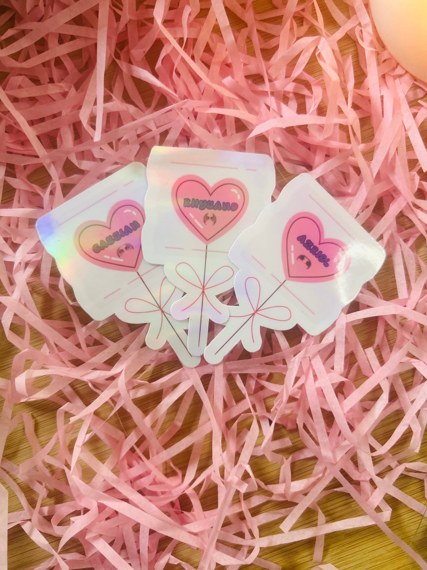 Holographic ACOTAR candy heart balloon stickers featuring Rhysand, Cassian, and Azriel. Perfect bookish merch for fantasy lovers, ideal for decorating laptops, water bottles, and journals.