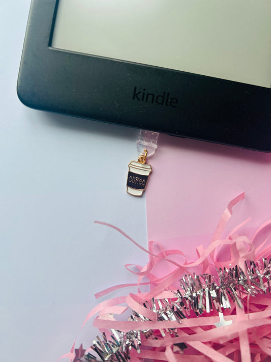 Kindle device with a coffee cup charm and pink ribbon on a light gray background