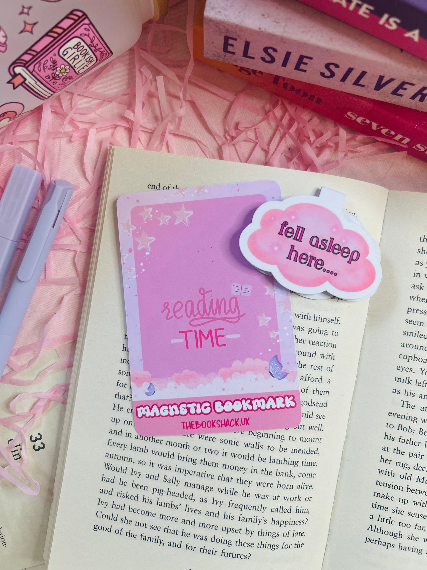 Cloud-shaped magnetic bookmark with the phrase ‘Fell Asleep Here...’ on soft pastel packaging, styled on an open book with cosy pink surroundings.