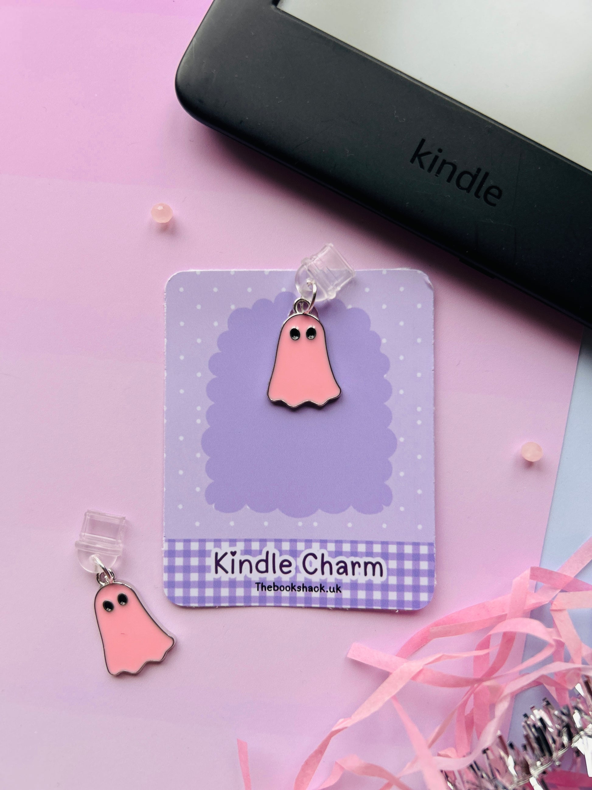 Pink ghost Kindle charm attached to a clear plastic Type-C dust plug, displayed with backing card and holographic packaging, with optional white letter charm.