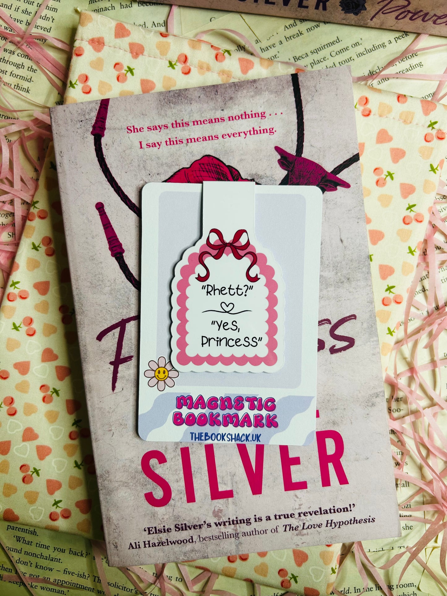 "Magnetic bookmark with the quote 'Rhett? Yes, Princess' in a pink scalloped design, displayed on Elsie Silver's romance novel 'Flawless.'