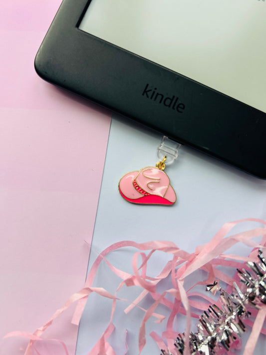 Pink cowboy hat Kindle charm attached to a clear plastic Type-C dust plug, packaged with backing card and holographic bag, shown with optional white letter charm.