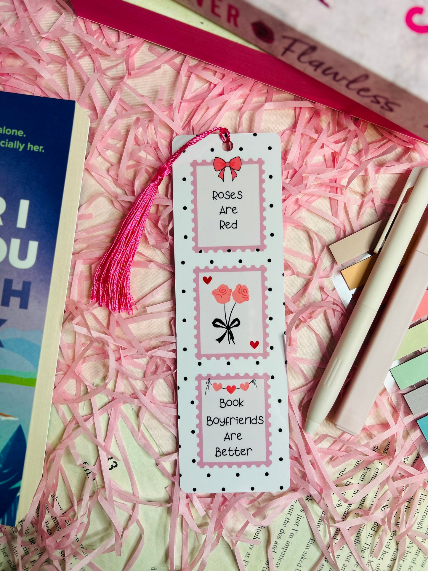 Aesthetic romance-themed bookmark with "Roses Are Red, Book Boyfriends Are Better" quote, featuring a pink tassel, cute heart and rose illustrations, and a polka dot design.