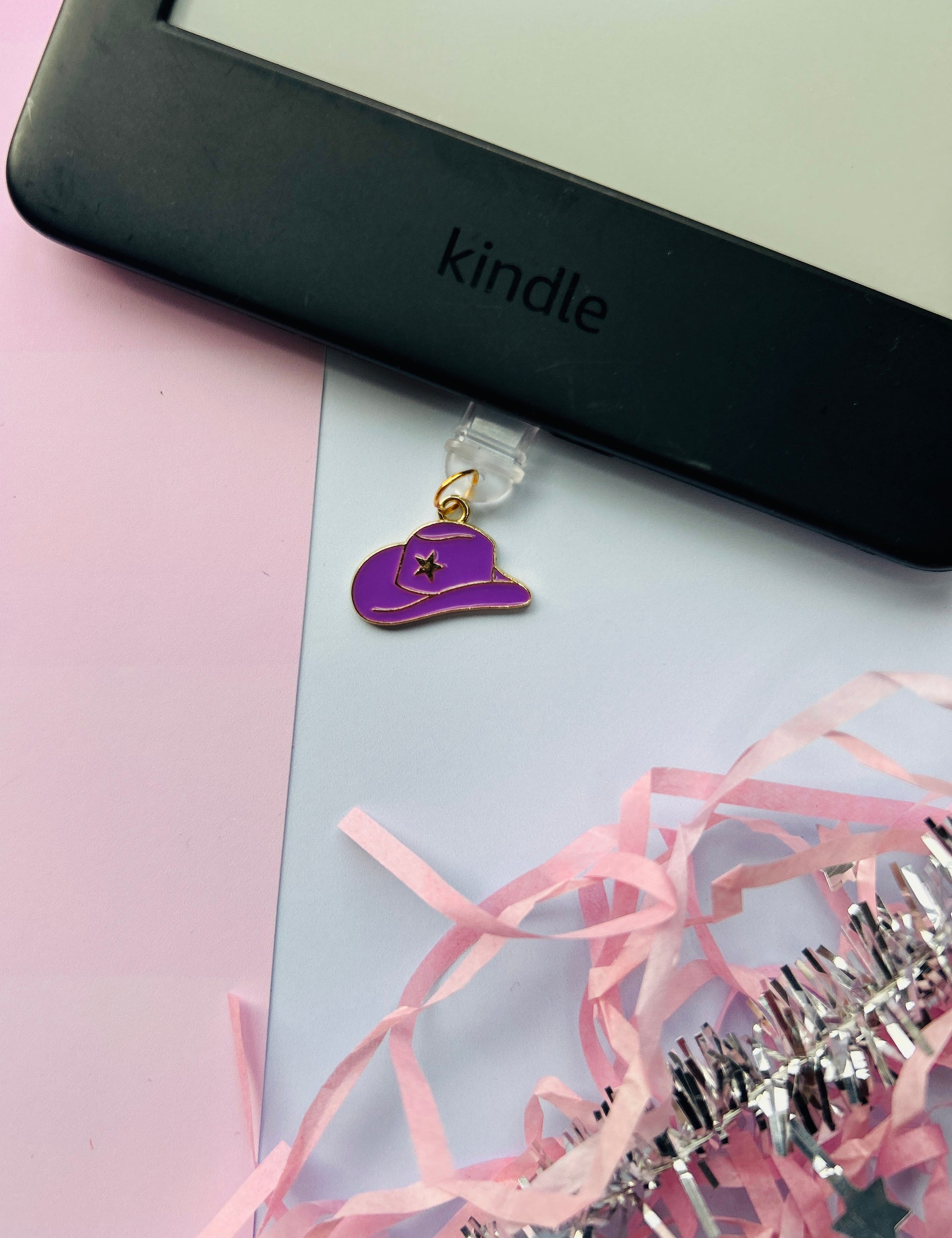 Purple cowboy hat Kindle charm attached to a clear plastic Type-C dust plug, displayed with backing card and holographic packaging, with optional white letter charm.