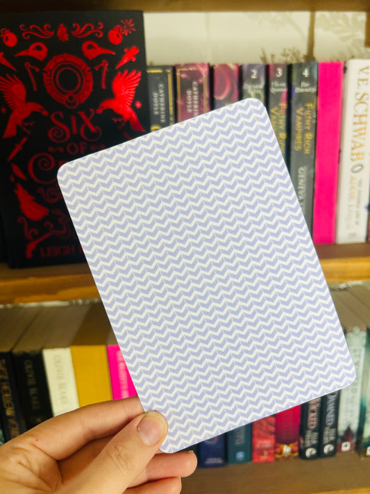 kindle insert with a zigzag pattern in front of a bookshelf with books.