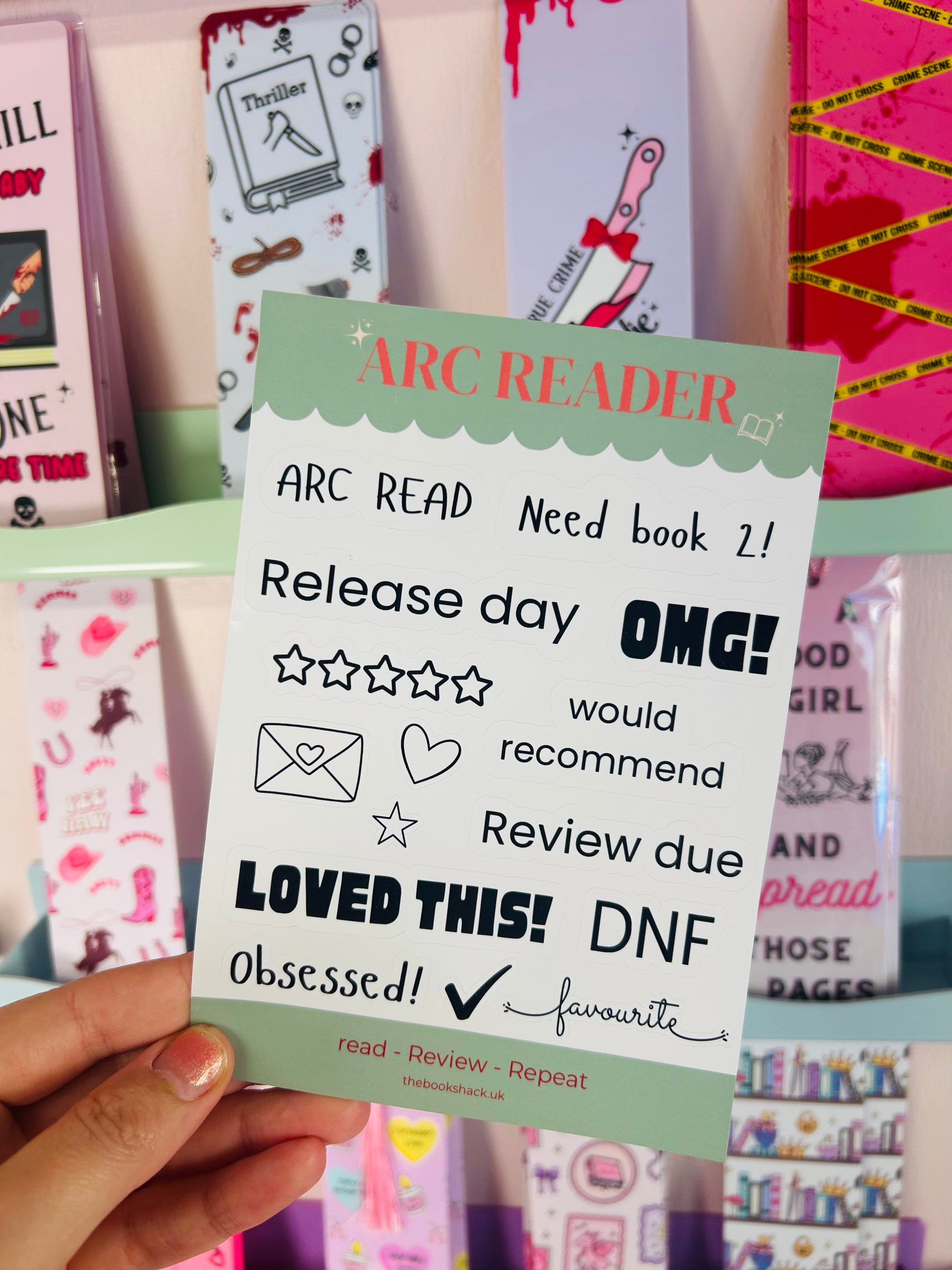 ARC Reader sticker sheet held up, featuring review, OMG!, and heart/mailing icons