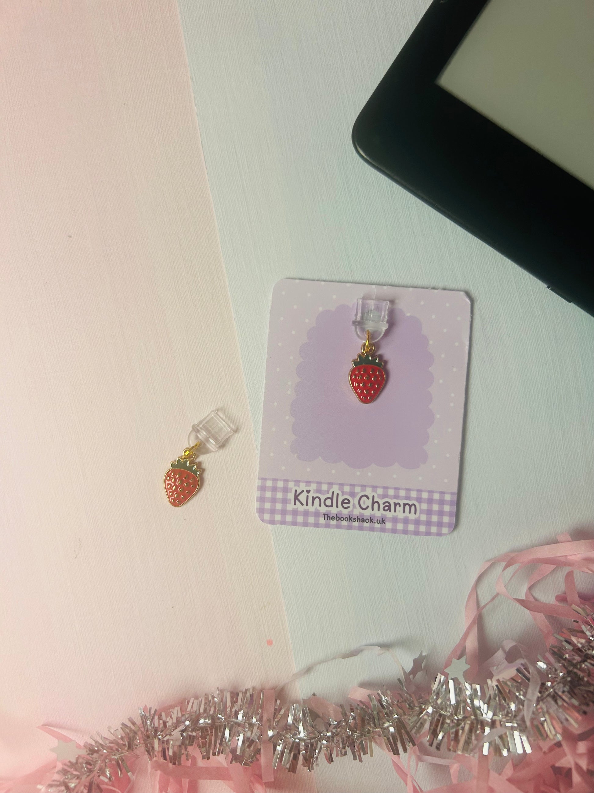 USB-C dust plug charm with strawberry enamel pendant on a Kindle Charm card