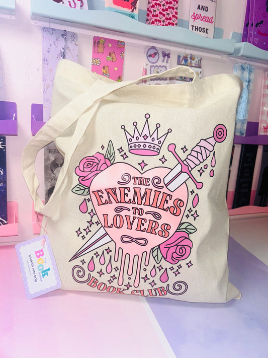 Cream cotton tote bag with pink “Enemies to Lovers” lettering, crown and roses