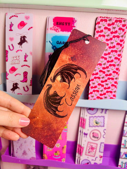 Orange glitter bookmark with face art and 'I will find you' quote, held in hand