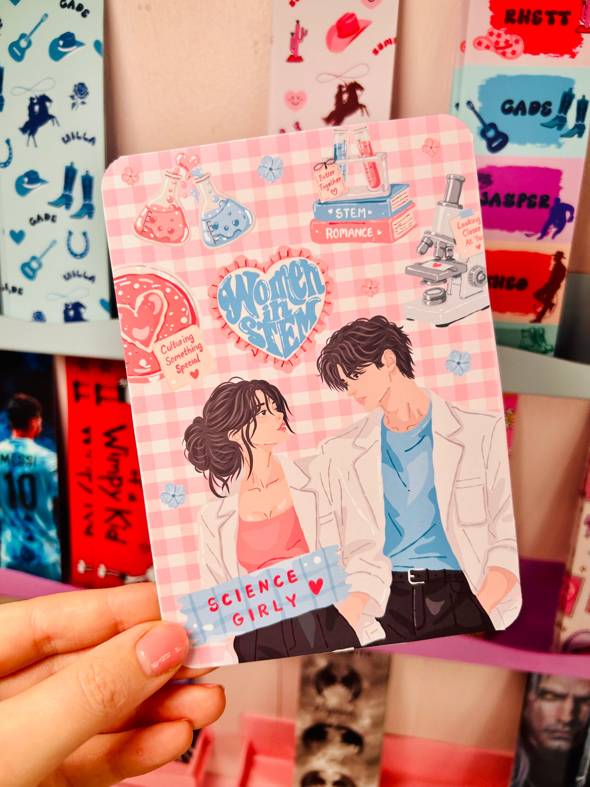 Double-sided STEM romance Kindle insert, pink science couple design, held in hand