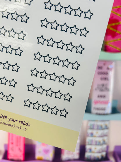 Close-up of star rating sticker icons with dark navy outlined stars on pale paper