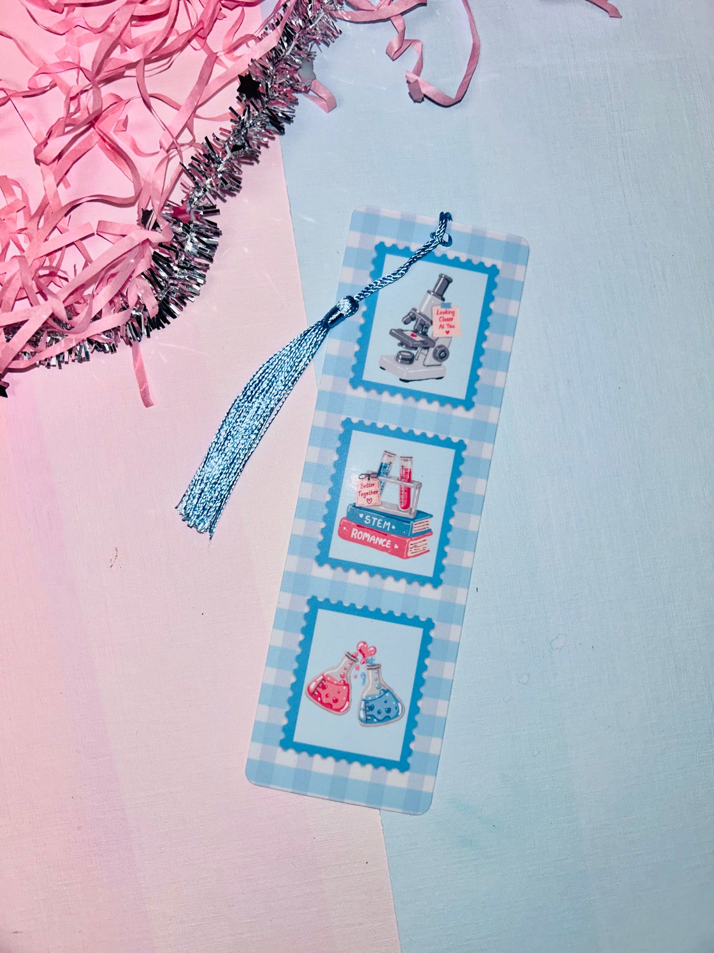 STEM romance postage stamp bookmark with blue tassel, three science-themed stamp panels