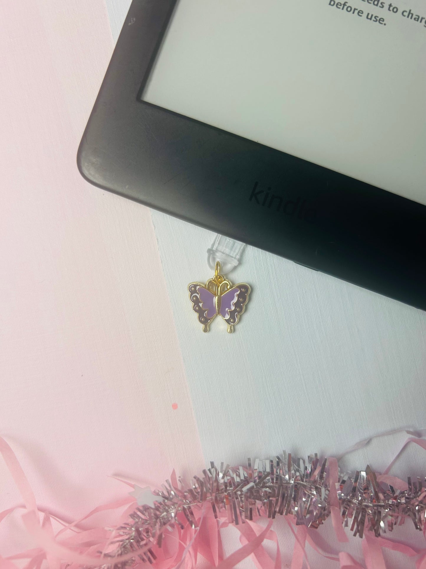 Purple butterfly USB-C dust plug charm with gold-tone frame and dangling accents