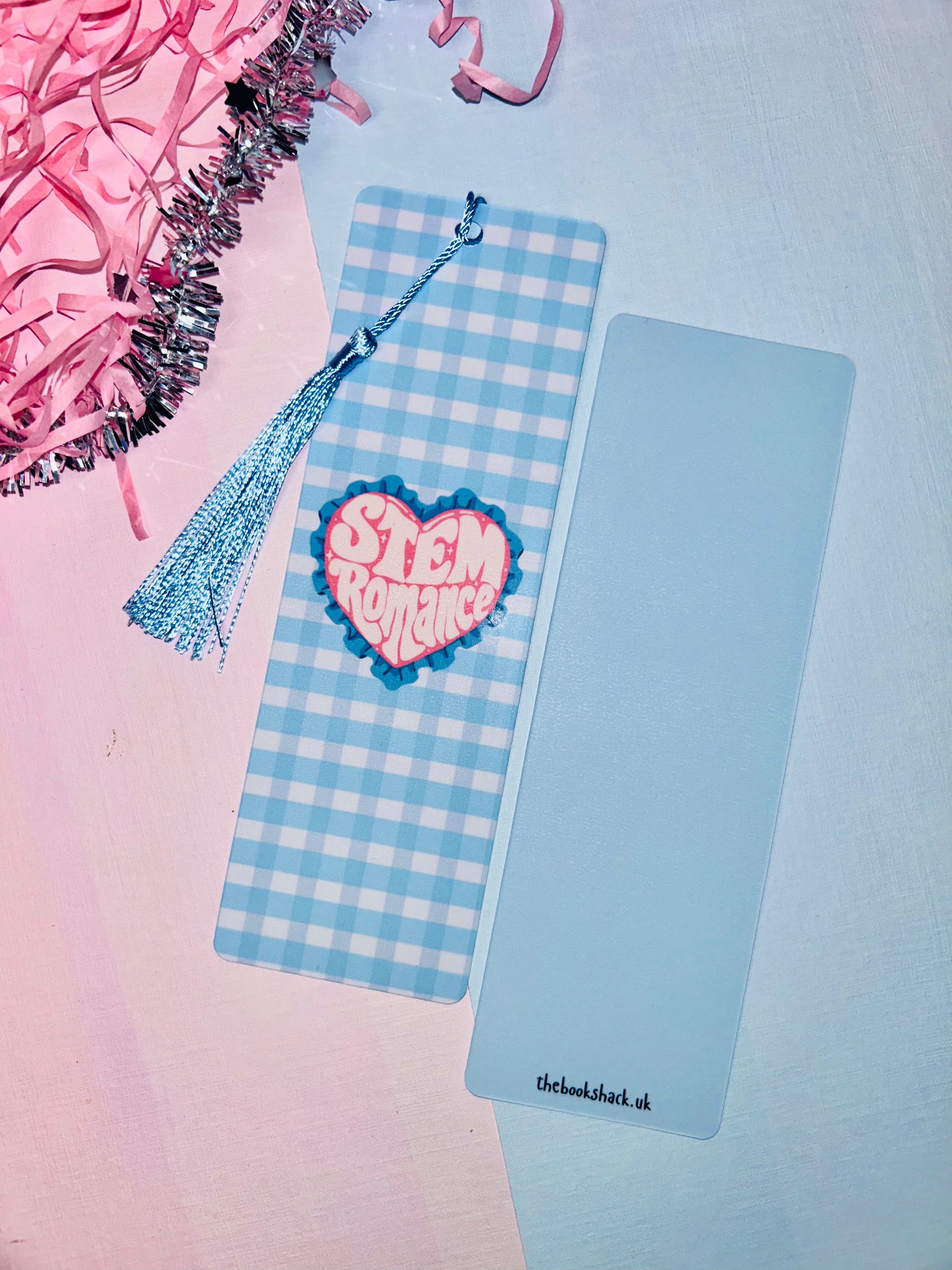 Double-sided science romance bookmark: blue check front, pink heart badge, blue tassel, back shown
