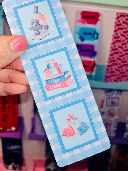 STEM romance postage stamp bookmark held in hand, three lab and potion stamp panels
