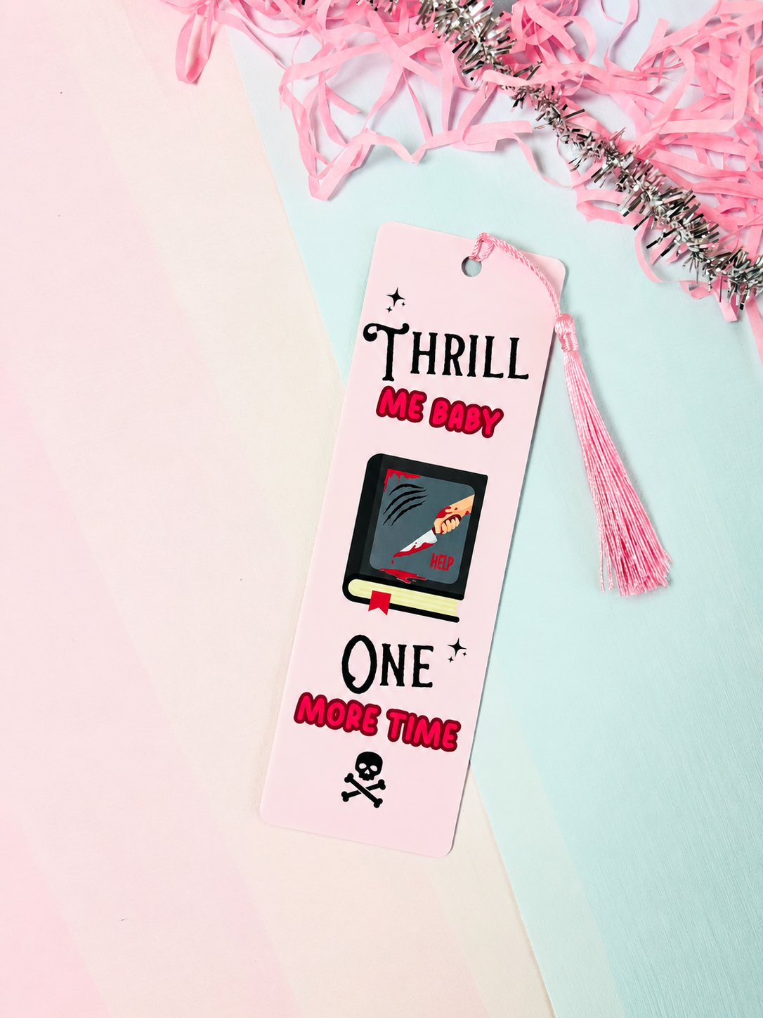 Pink and white bookmark with pink tassel, 'THRILL ME BABY' and 'ONE MORE TIME'.