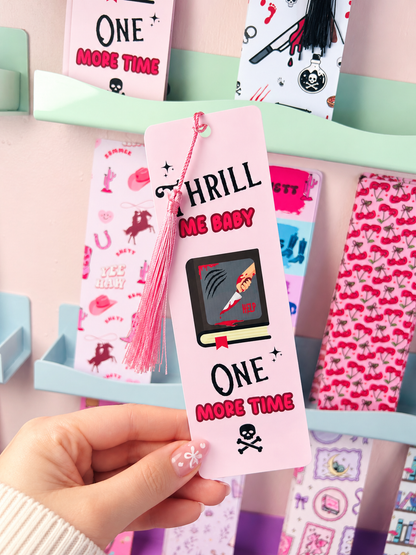 Pink crime-themed bookmark with tassel, 'THRILL ME BABY' and 'ONE MORE TIME' text.