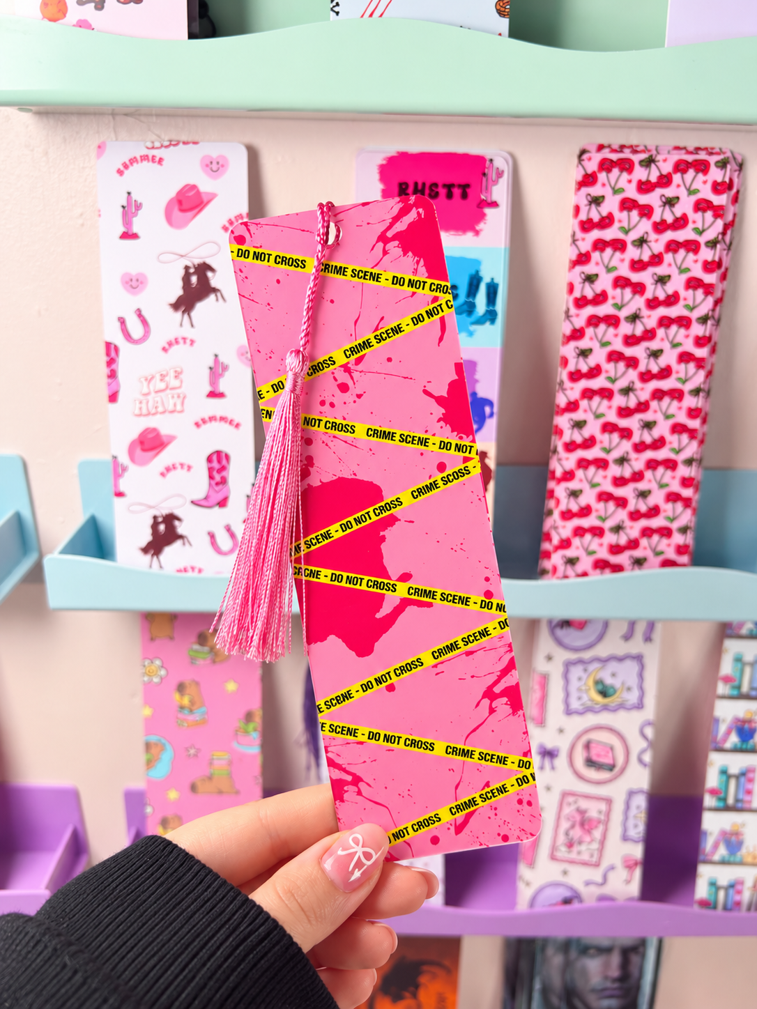 Pink crime-scene bookmark with neon tape pattern and pink tassel
