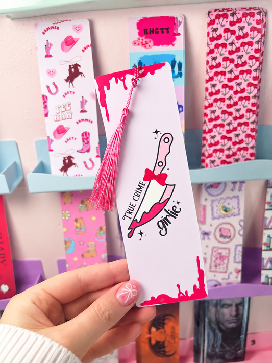 White bookmark with magenta tassel, true crime girly graphic and star accents
