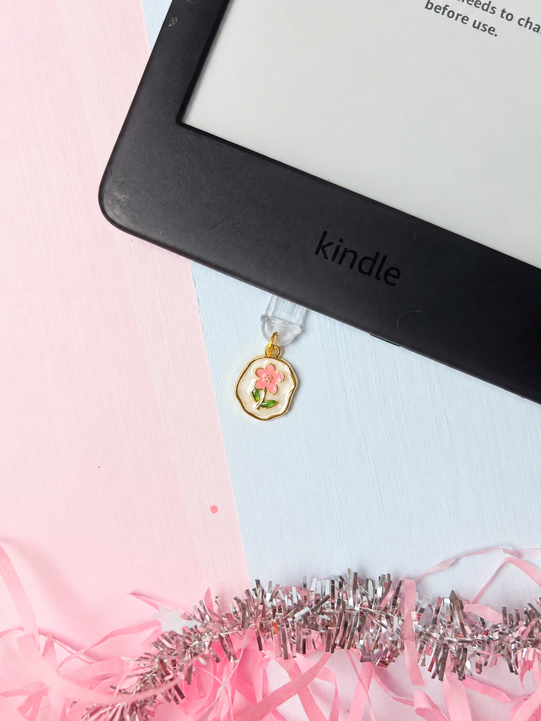 Gold-tone Kindle USB-C dust plug charm with pink flower and green leaf detail