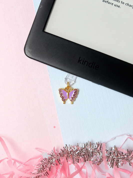 Purple butterfly USB-C dust plug charm with gold-tone frame and dangling hook