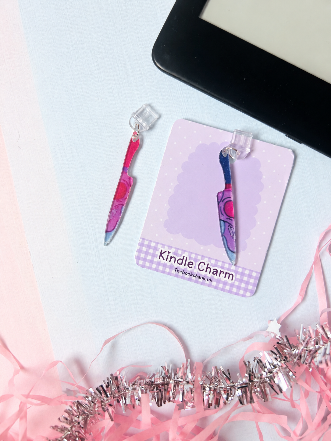 Purple knife-shaped Kindle dust plug charm on purple scalloped card