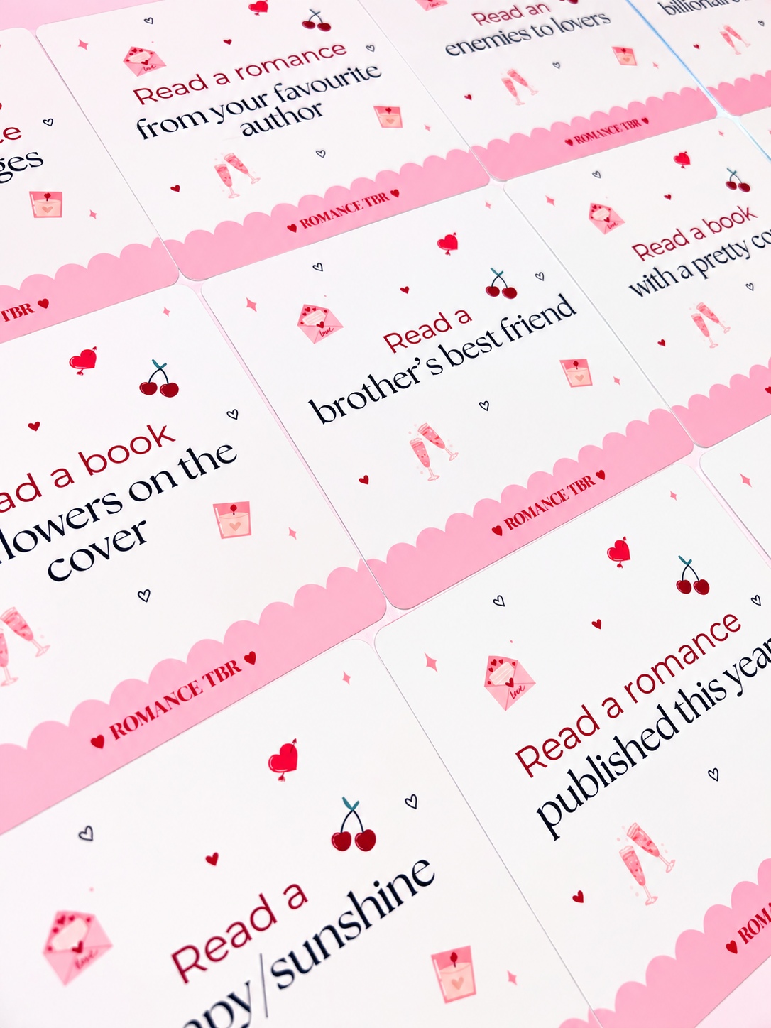 Romance TBR prompt cards scattered, featuring heart icons and scalloped pink edges