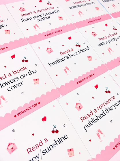 Romance TBR prompt cards scattered, featuring heart icons and scalloped pink edges