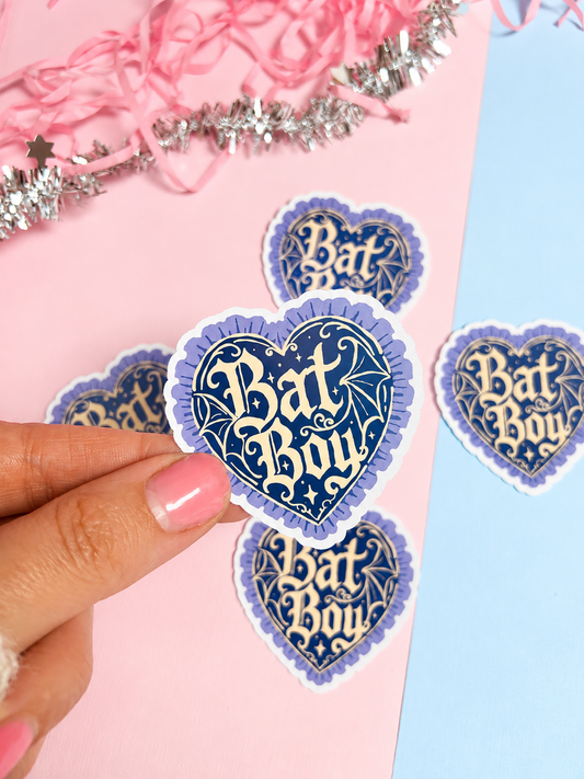 Heart holographic sticker with blue bat-themed design and 'Bat Boy' text, held in hand