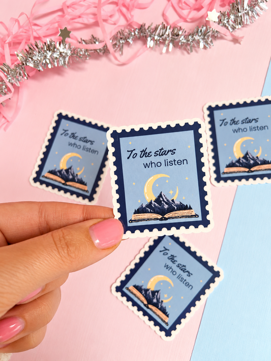 Holographic postage-stamp stickers, moon over mountain with open book, held in hand