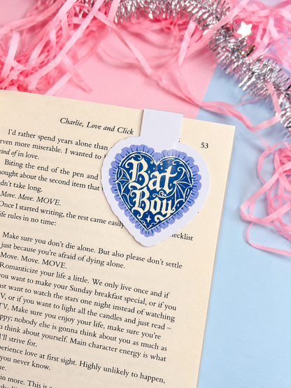 Blue heart Bat Boy magnetic bookmark clipped to an open book page
