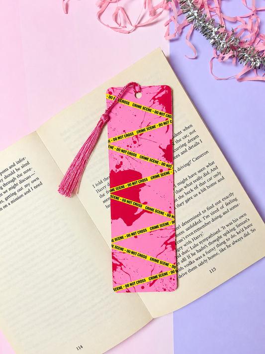 Pink crime-scene bookmark with neon yellow evidence tape and pink tassel fringe.
