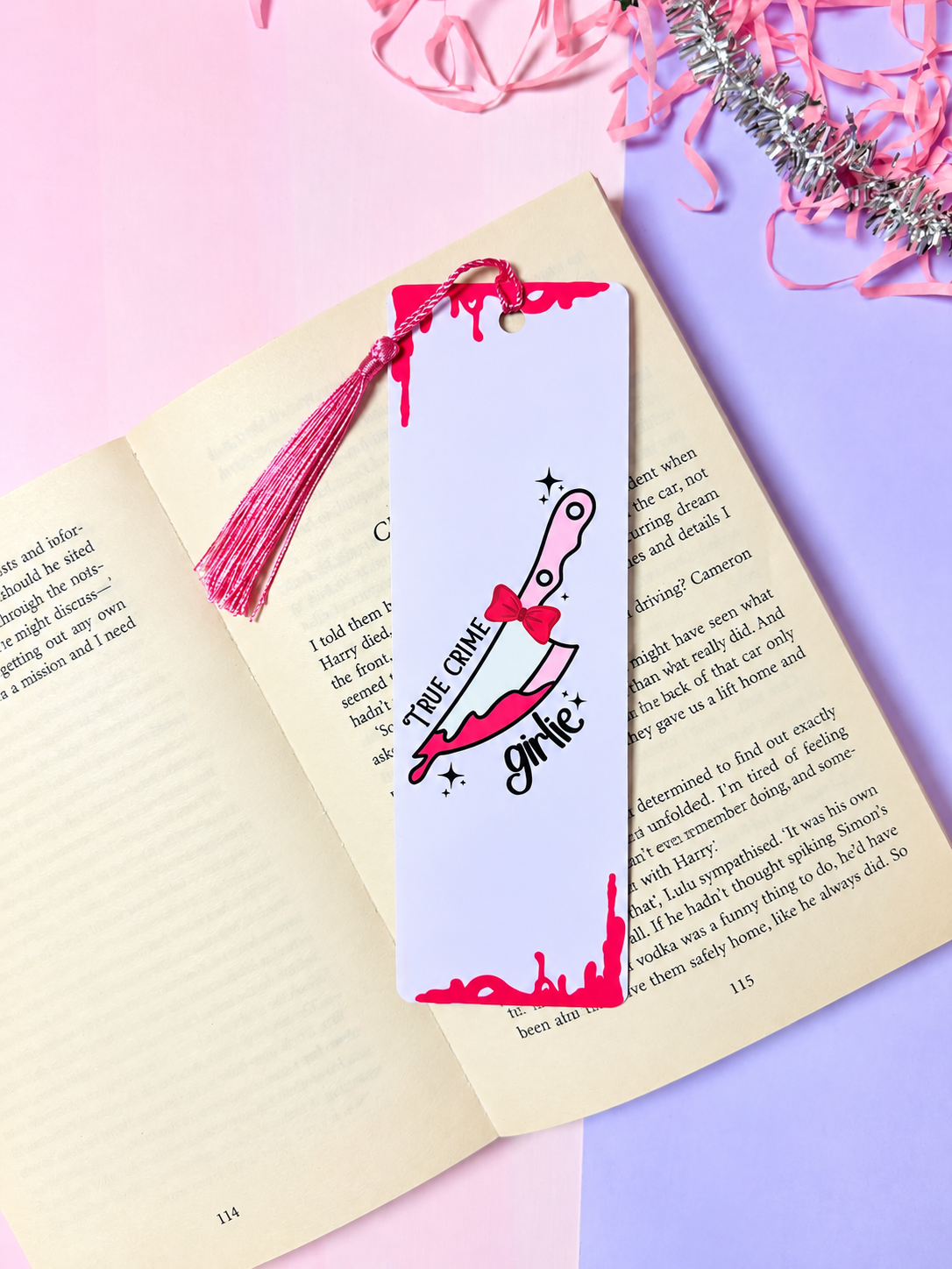 Crime-themed bookmark with pink tassel, illustrated skeleton-cat graphic