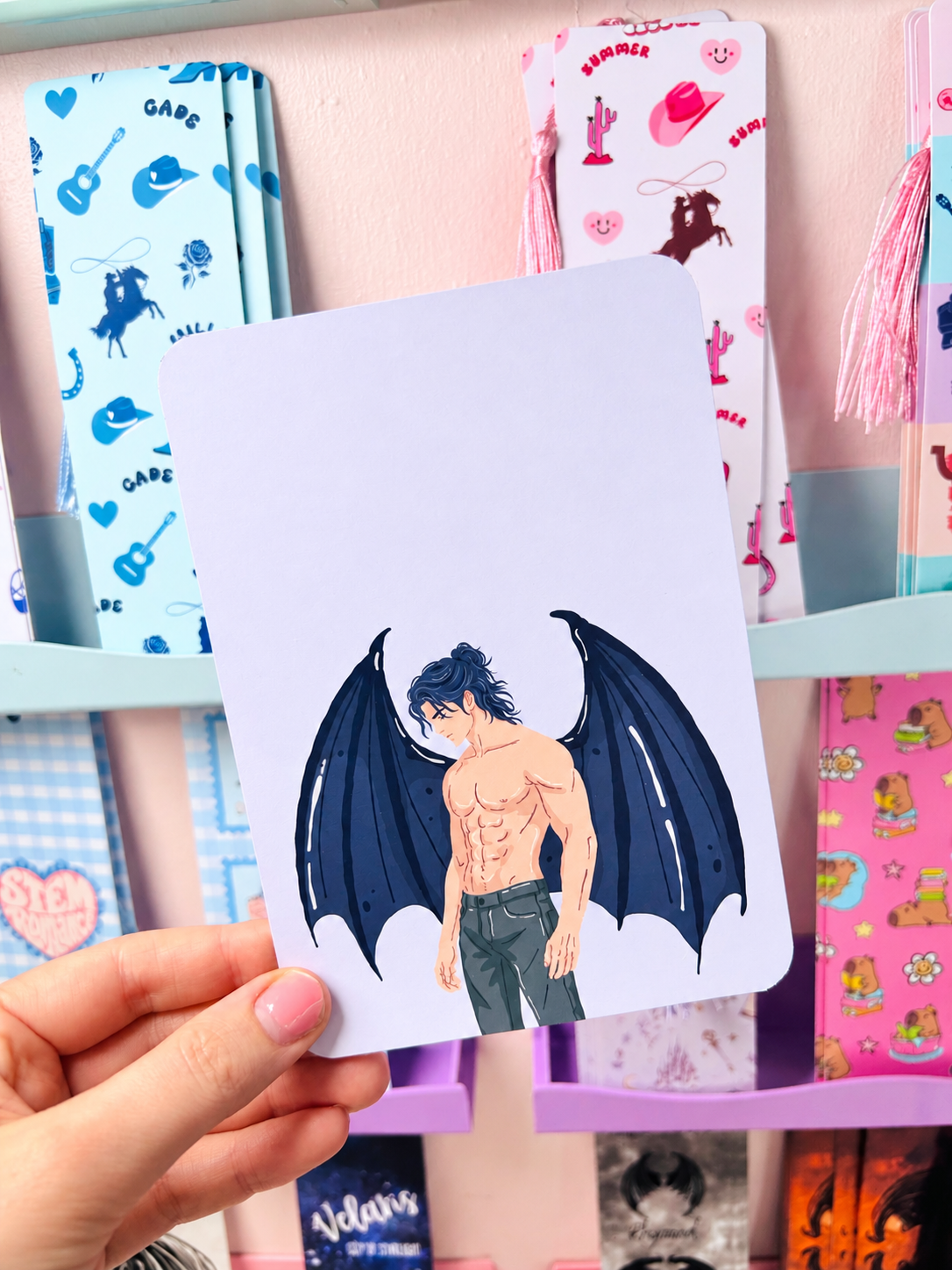Double-sided Kindle insert card with blue winged character illustration on a white background.