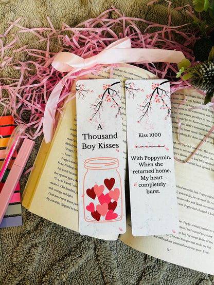 Romantic bookmarks inspired by the novel 'A Thousand Boy Kisses,' featuring cherry blossom branches, a heart-filled jar, and emotional quotes