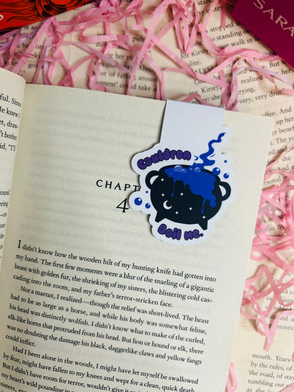 Book with a decorative bookmark featuring a blue character and text on a pink ribbon background.