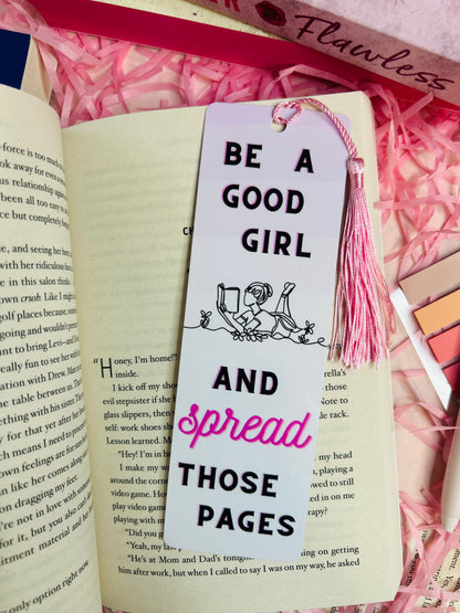 Aesthetic tassel bookmark with the quote 'Be a Good Girl and Spread Those Pages' placed on a romance book