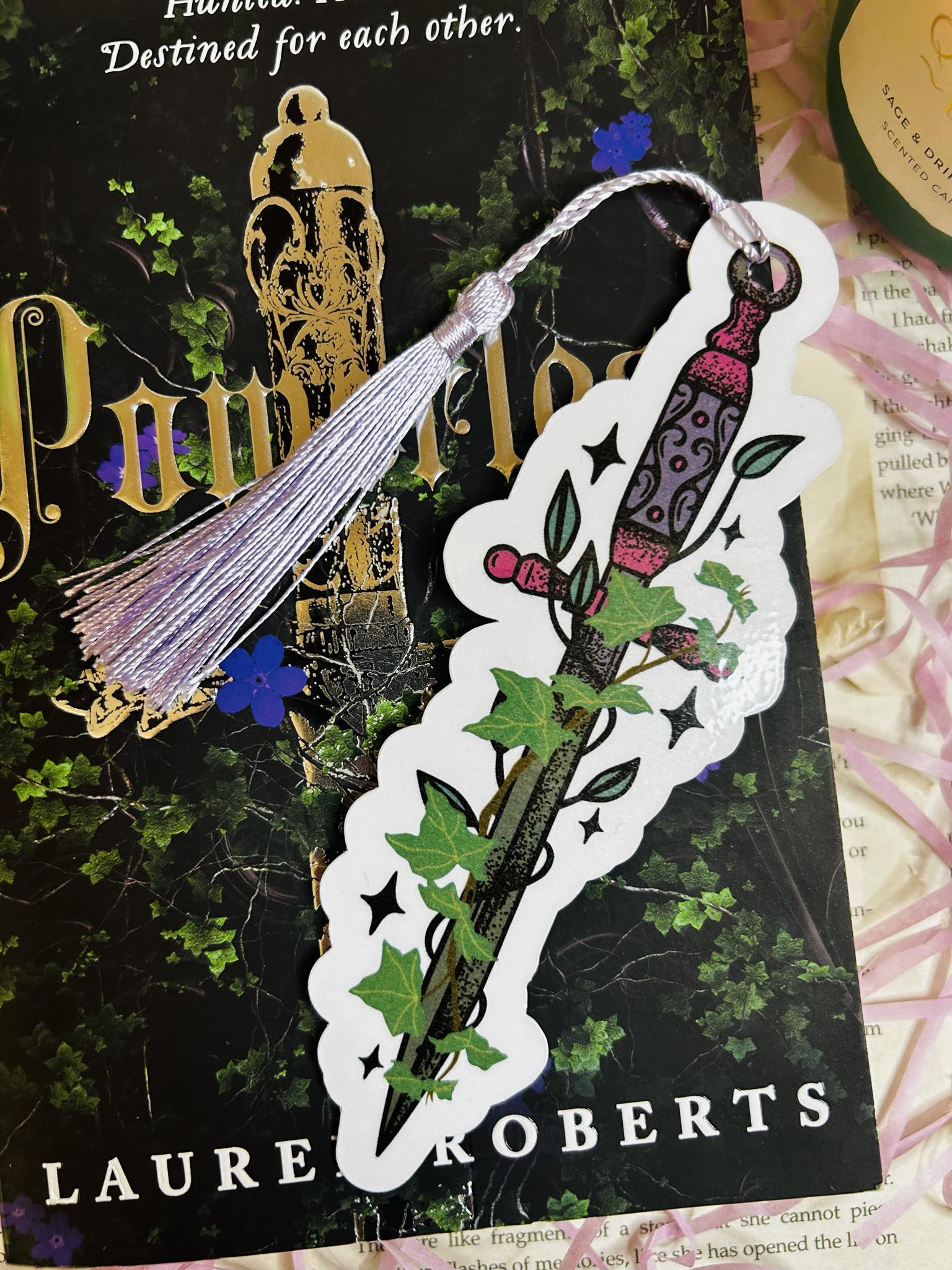 Die-cut bookmark shaped like a fantasy dagger entwined with ivy, perfect for dark fantasy and romantasy lovers, sat on top of Powerless book by Lauren roberts