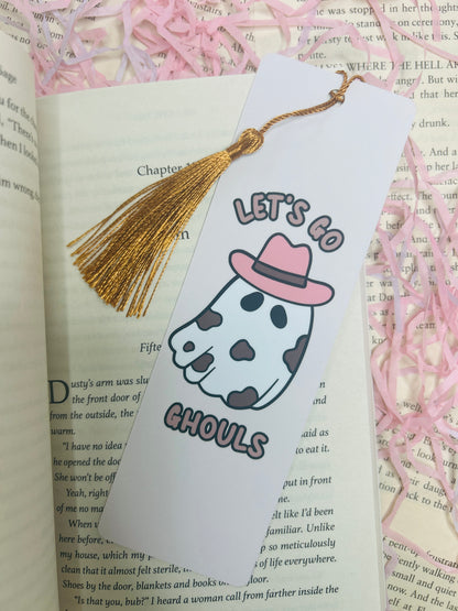 Double-sided bookmark: one side shows a cow-print ghost with a pink cowboy hat and text “Let’s Go Ghouls,” the reverse side has a pastel pink plaid pattern.