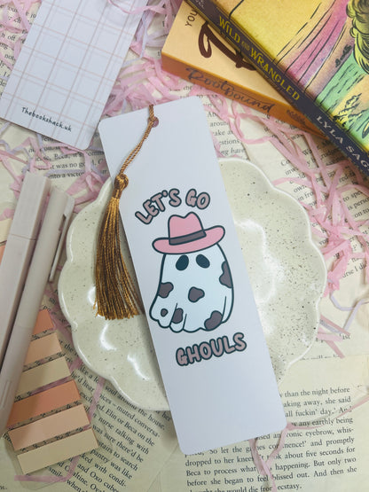 Double-sided bookmark: one side shows a cow-print ghost with a pink cowboy hat and text “Let’s Go Ghouls,” the reverse side has a pastel pink plaid pattern.