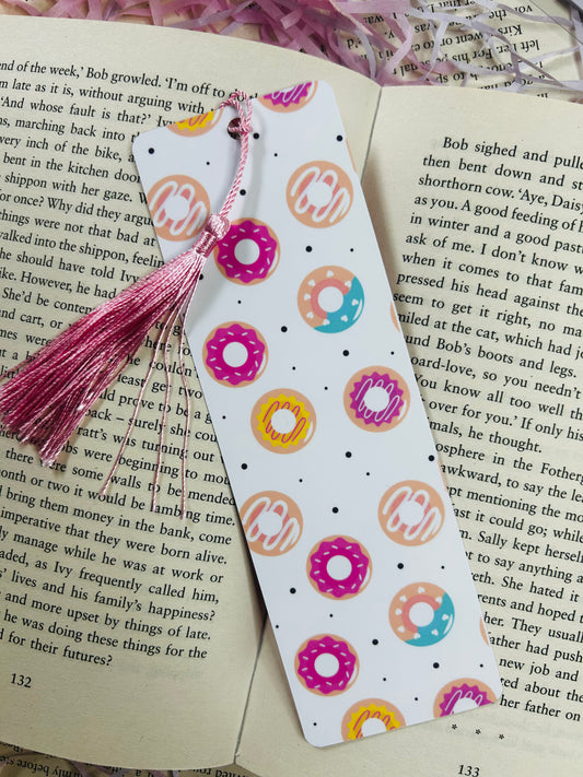 Cute donut-themed laminated bookmark with colourful sprinkles and optional tassel, double-sided and displayed on a book.