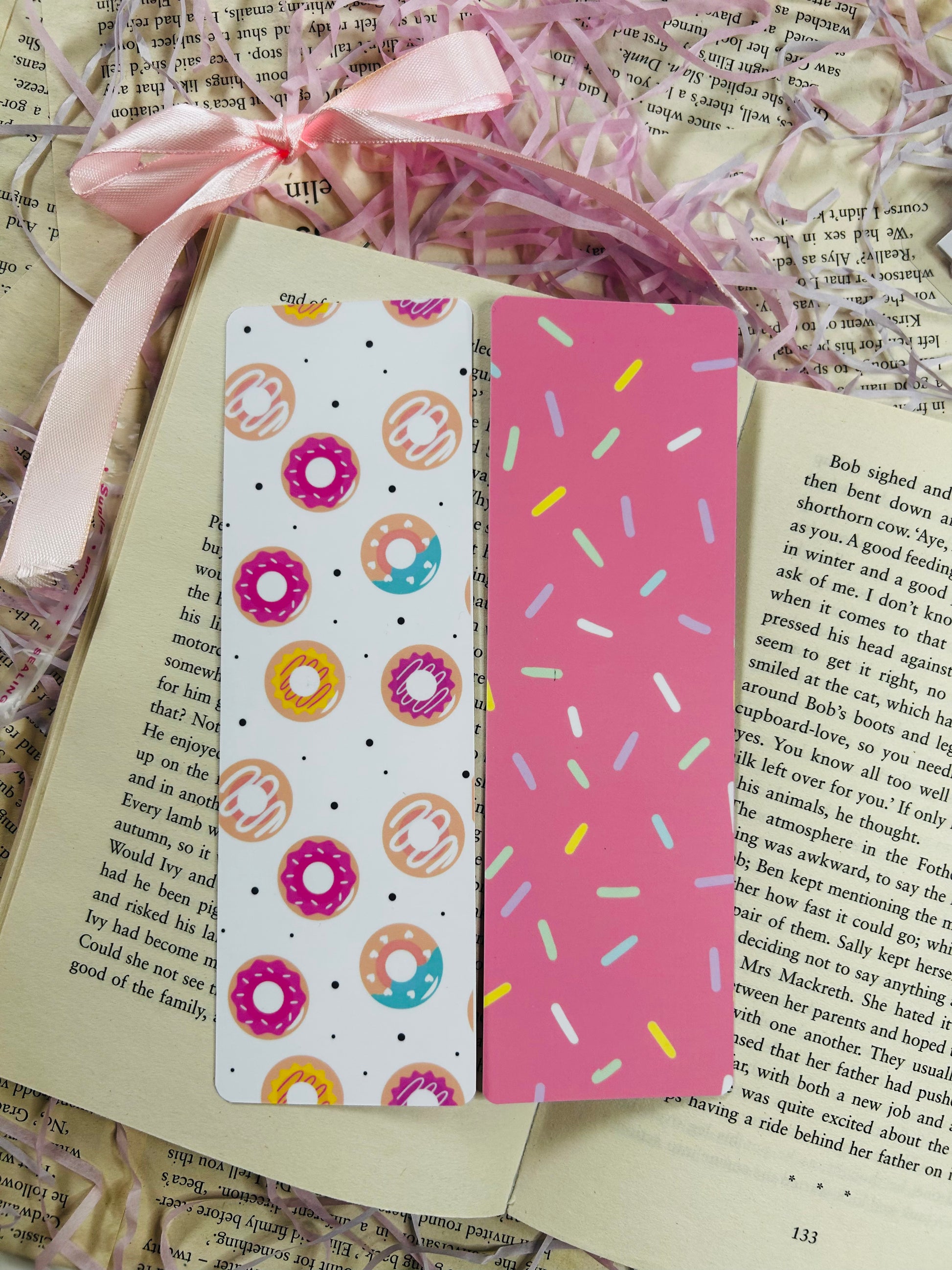 Cute donut-themed laminated bookmark with colourful sprinkles and optional tassel, double-sided and displayed on a book.