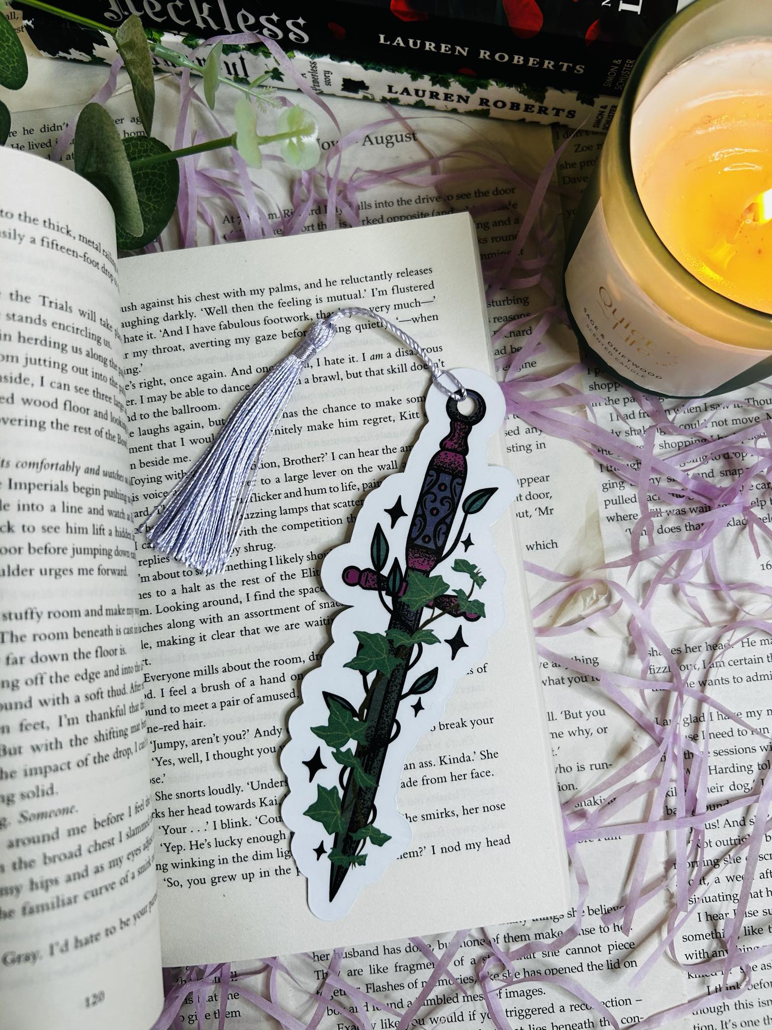 Die-cut bookmark shaped like a fantasy dagger entwined with ivy, perfect for dark fantasy and romantasy lovers, sat on top of Powerless book by Lauren roberts