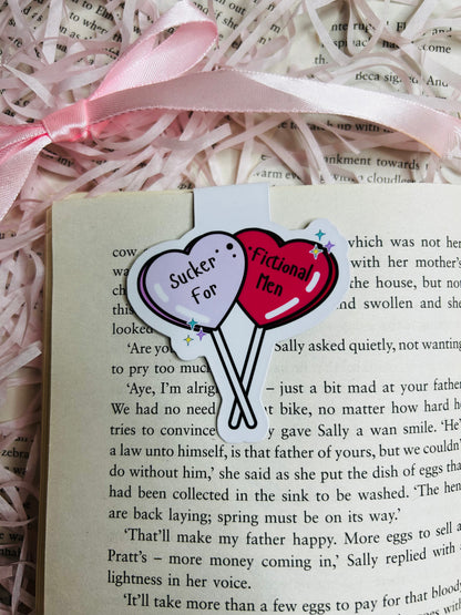 Magnetic bookmark with a playful design featuring two heart-shaped balloons reading 'Sucker for Fictional Men.