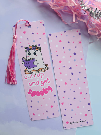 Two pink bookmarks with star patterns and a tassel on a light purple background.