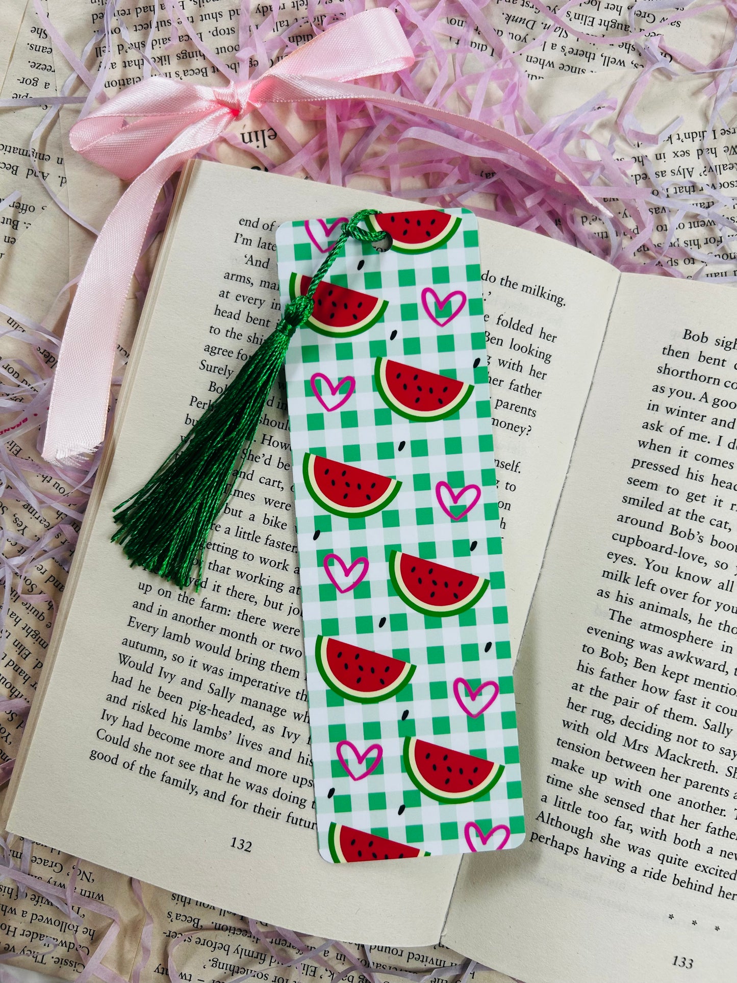 Set of colorful gingham bookmarks with fruit illustrations including cherries, strawberries, and citrus, placed on an open book.