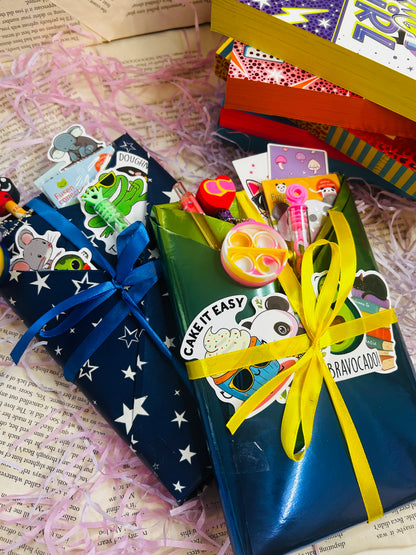 Mystery book bundle for kids with a surprise book, bookmark, bubbles, stickers, and packaging on pink shredded filler.